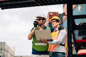 Team Engineer and worker wear safety uniform check control loading freight cargo container use computer laptop at commercial dock warehouse,transportation import,export logistic industrial service photo