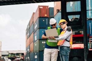 Team Engineer and worker wear safety uniform check control loading freight cargo container use computer laptop at commercial dock warehouse,transportation import,export logistic industrial service photo