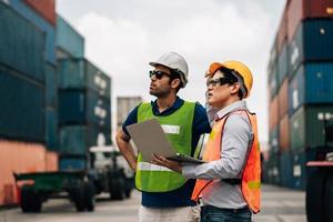 Team Engineer and worker wear safety uniform check control loading freight cargo container use computer laptop at commercial dock warehouse,transportation import,export logistic industrial service photo
