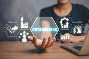outsourcing global reclutamiento negocio y Internet concepto, negocio persona mano participación outsourcing icono en virtual pantalla con azul bokeh antecedentes. foto