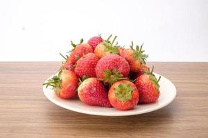 Group of Red strawberries in white bowl on wooden desk, tasty dessert, Close up. photo