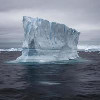 un enorme transparente bloquear de hielo soportes alrededor el parte superior de el iceberg y el viento golpes frío, generar ai foto