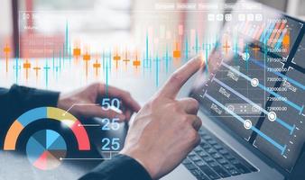 financial investment concept, businessman working on computer laptop and virtual trading graph in concept of investment business growth and marketing photo