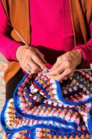 old woman with knitting needles and wool photo