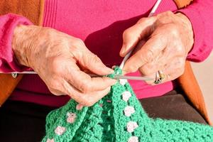 old woman with knitting needles and wool photo