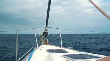 mujer en un amarillo sombrero y azul vestir niña descansa a bordo un yate cerca el faro en verano temporada a Oceano video