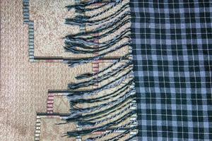 Texture of checkered white, blue wool. Fringed hem. Checkered blue and white textured fabric background closeup photo