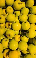 Background of ripe fresh yellow apples at the food market. Top view. photo