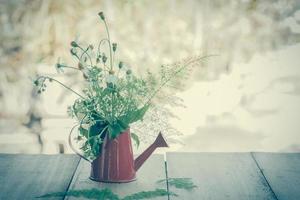 Decoration with small flowers in a red watercan photo