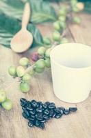 Fresh coffee beans on wood and coffee cup photo