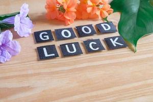 Good luck tag with flower on wood table. photo