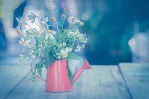 Decoration with small flowers in a red watercan photo