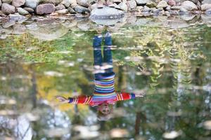 reflexión de un niño en el otoño lago. foto