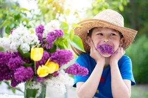 Funny child in panama with a lilac. Happy boy in the summer. photo