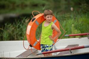 un niño con un vida boya es en el barco . foto