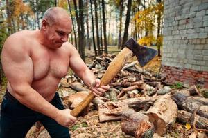 A strong man chopping wood. photo