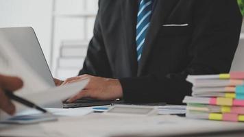 Financial analysts analyze business financial reports on a digital tablet planning investment project during a discussion at a meeting of corporate showing the results of their successful teamwork. video