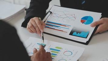 Financial analysts analyze business financial reports on a digital tablet planning investment project during a discussion at a meeting of corporate showing the results of their successful teamwork. video