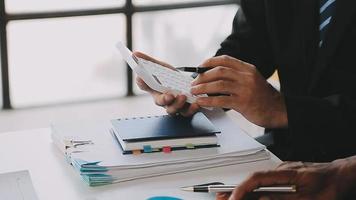 Financial analysts analyze business financial reports on a digital tablet planning investment project during a discussion at a meeting of corporate showing the results of their successful teamwork. video