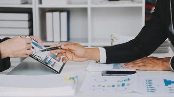 Financial analysts analyze business financial reports on a digital tablet planning investment project during a discussion at a meeting of corporate showing the results of their successful teamwork. video