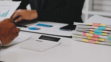 Financial analysts analyze business financial reports on a digital tablet planning investment project during a discussion at a meeting of corporate showing the results of their successful teamwork. video