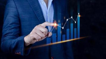 Businessman finger touch symbol stock graph and chart background, concept growth and development business investment, Stock market and strategy making market plan and stock market fluctuations photo