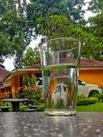 Glass filled with water on table outdoors photo