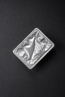 Rectangular plastic box with yogurt or cheese hermetically sealed with a foil lid photo