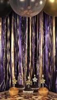 Vertical video of party celebration props birthday gold, violet and black, balloons, candles