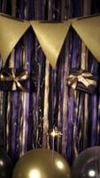 Vertical video of party celebration props birthday gold, violet and black, balloons, candles