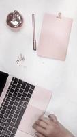 Vertical video of rose gold pink laptop, notebook and objects on white background