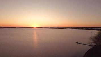 Blick auf die Sonne, die sich in einer Flusslandschaft spiegelt video