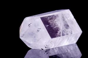 Cristal de roca de cristal de piedra mineral macro sobre un fondo negro foto
