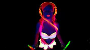 female disco raver girl poses in UV costume with spinning led poi lights video