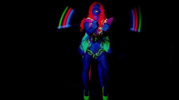 female disco raver girl poses in UV costume with spinning led poi lights video