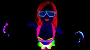 vrouw disco raver meisje poses in uv kostuum met spinnen LED poi lichten video