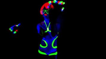 female disco raver girl poses in UV costume with spinning led poi lights video