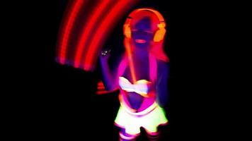hembra disco raver niña poses en uv disfraz con hilado LED poi luces video