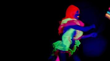 female disco raver girl poses in UV costume with spinning led poi lights video