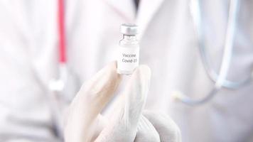 médico mão dentro luvas segurando coronavírus vacina video