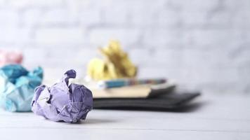 Crumpled paper ball and notepad on wooden table video