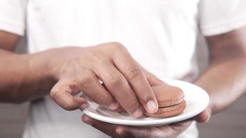 Hand pick chocolate color macaroon from a plate video