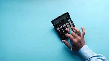 Rear view of man hand using calculator video