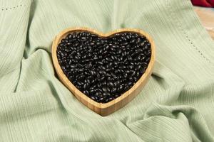 heart shaped black bean bowl on green tablecloth photo
