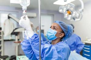 Doctor in the operating room putting drugs through an IV - surgery concepts photo