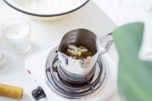 Woman making decorative aroma candles at table photo