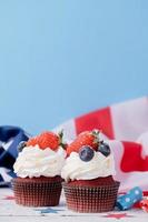 Sweet cupcakes with blueberries and strawberry , usa flag on blue background photo