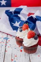 Sweet cupcakes with blueberries and strawberry , flag background photo