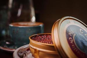 Black caviar in can placed on a plate with ice. photo