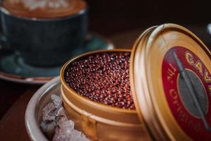 Black caviar in can placed on a plate with ice. photo